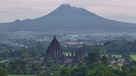 morning scenery on prambanan temple complex with mount merapi. panoramic view of temple and mountain, indonesia.