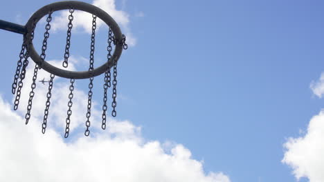 close up of a basketball hoop while an airplane is flying by