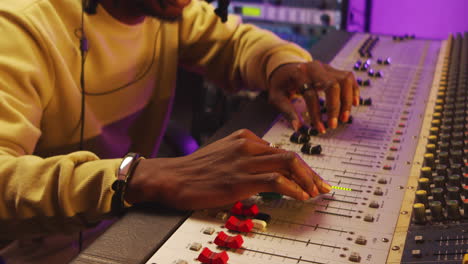 Close-Up-of-Black-Man-Working-with-Mixing-Desk-in-Recording-Studio