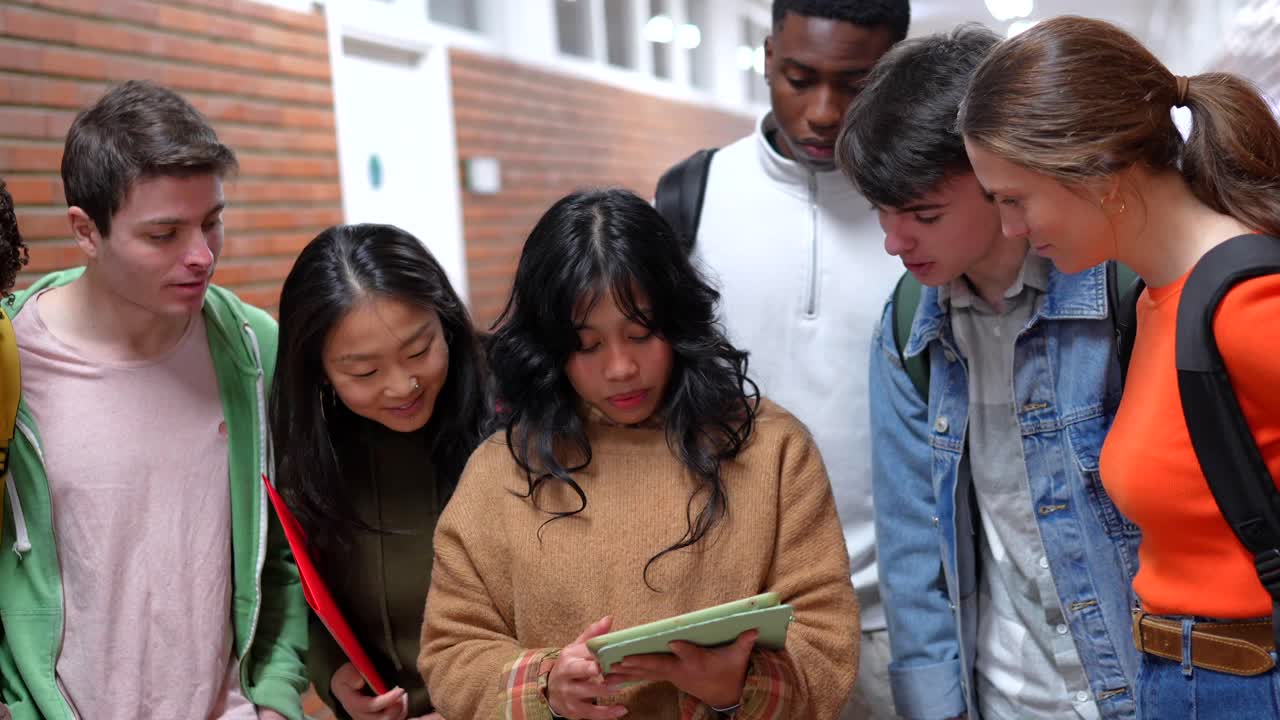 Group of students using a tablet in a school hallway