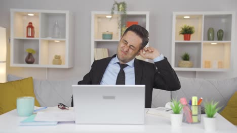 Home-office-worker-man-scratches-his-ears-looking-at-camera.