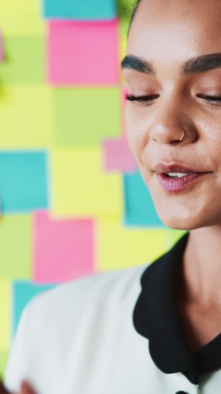 Giovane donna felice che sorride davanti a un muro di post-it colorati