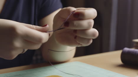 Close-up-of-a-woman's-hands-working-with-string-in-her-craft-workshop,-creating-leather-bindings-for-a-DIY-journal