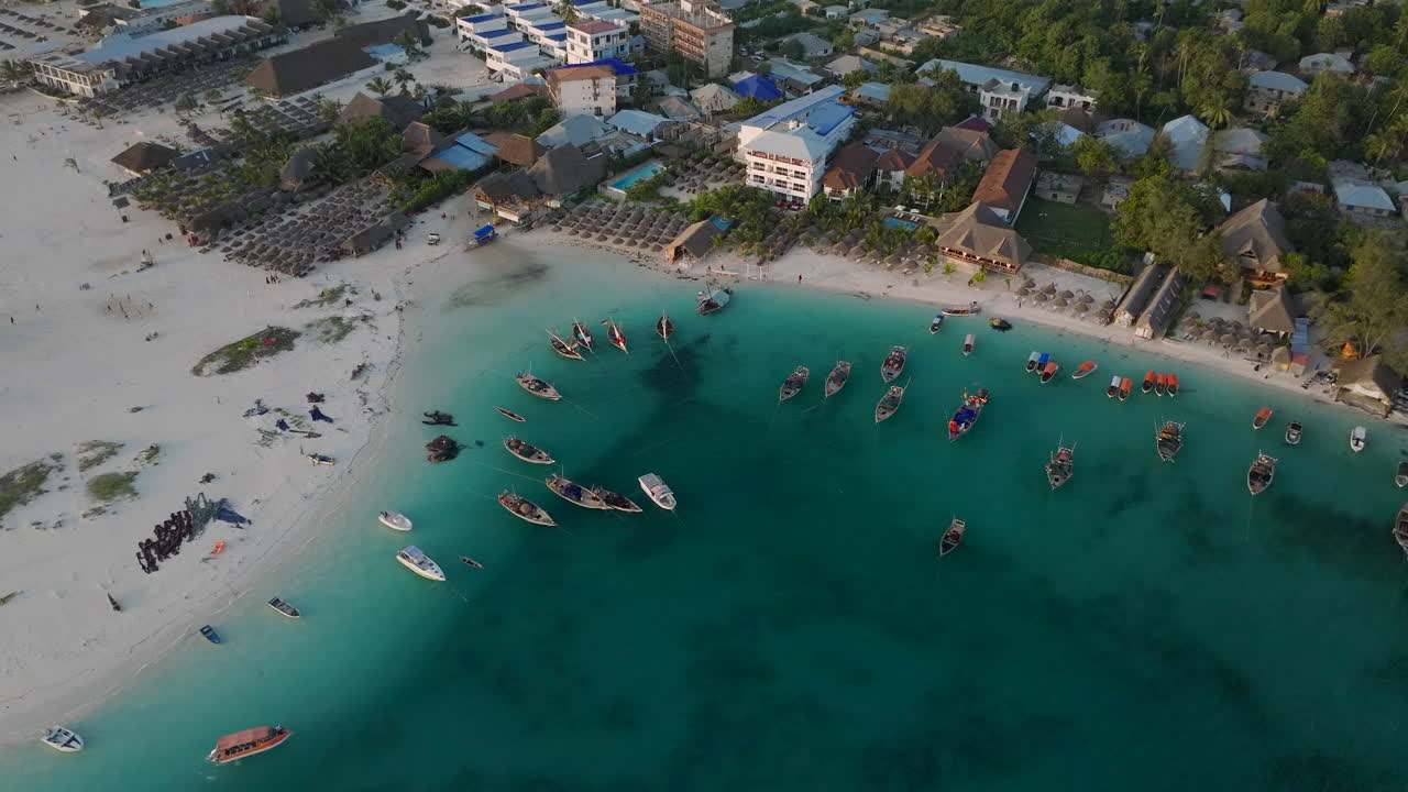 Zanzibar, Tanzanya'daki Kendwa köyünde ahşap balıkçı teknelerinin ve kumlu plajın 30 fps hızında çekilmiş havadan görünümü.