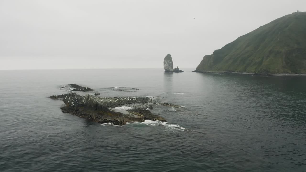 Aerial view of Sail Rock (Parus Rock) near Gelendzhik on Russia’s Black Sea coast. The iconic sea stack rises dramatically from the calm waters beside rugged cliffs under an overcast sky