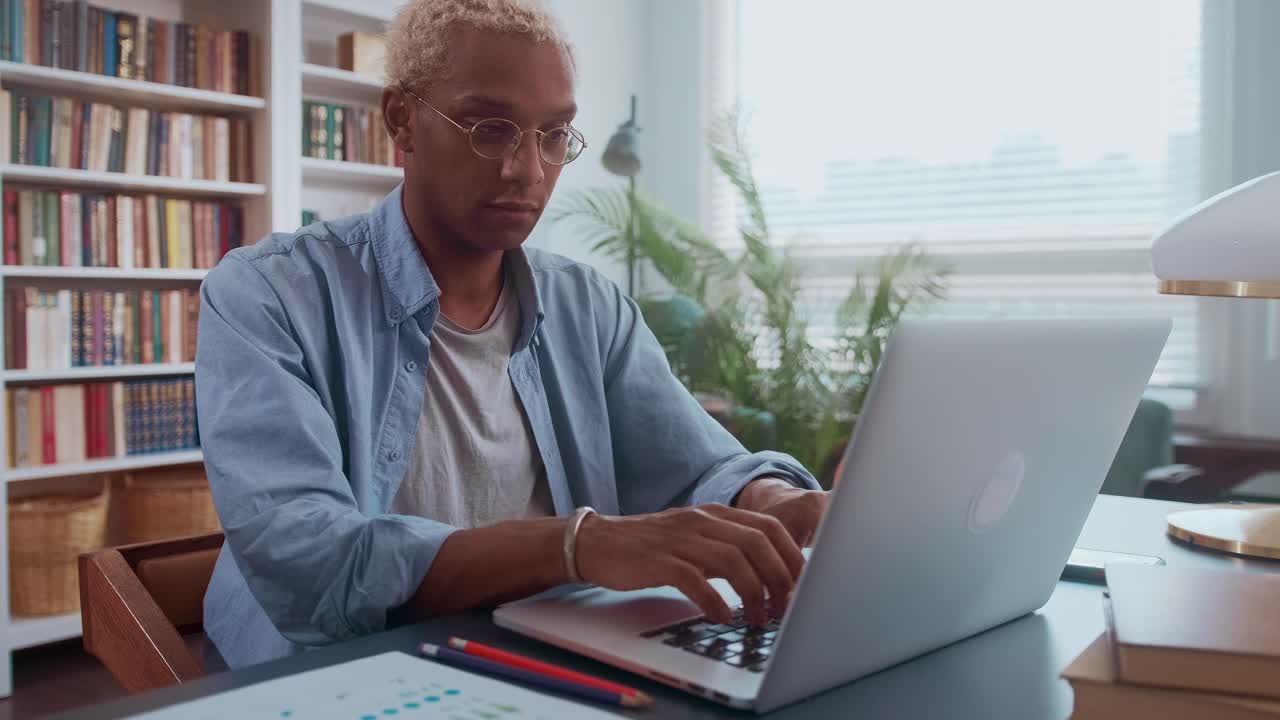 African american business man working on laptop with electronic documents