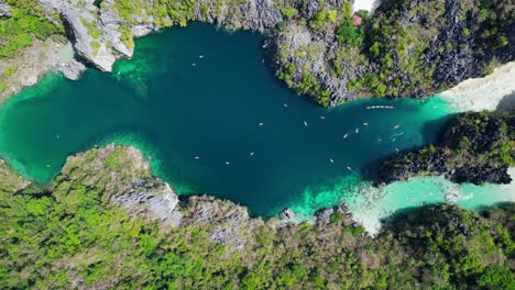 the big lagoon of el nido on sunny day, slow-rising aerial view