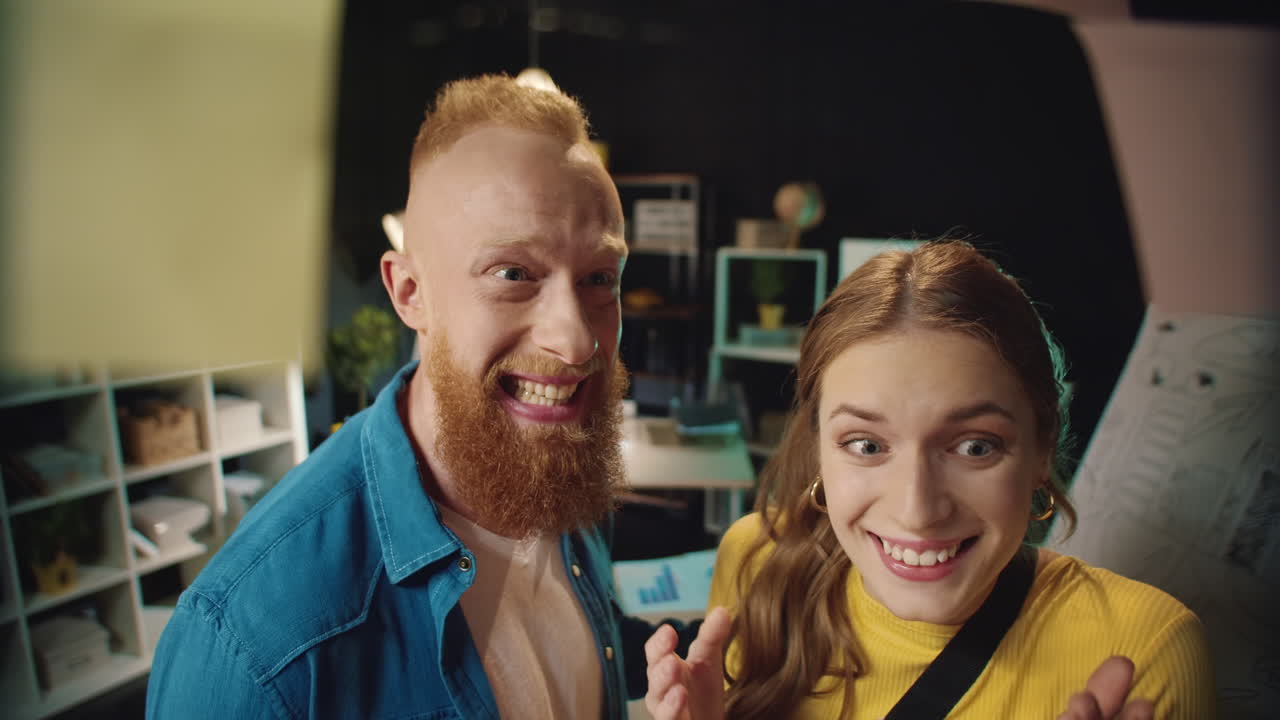 Happy hipster man and woman giving five near board with notes in workplace.