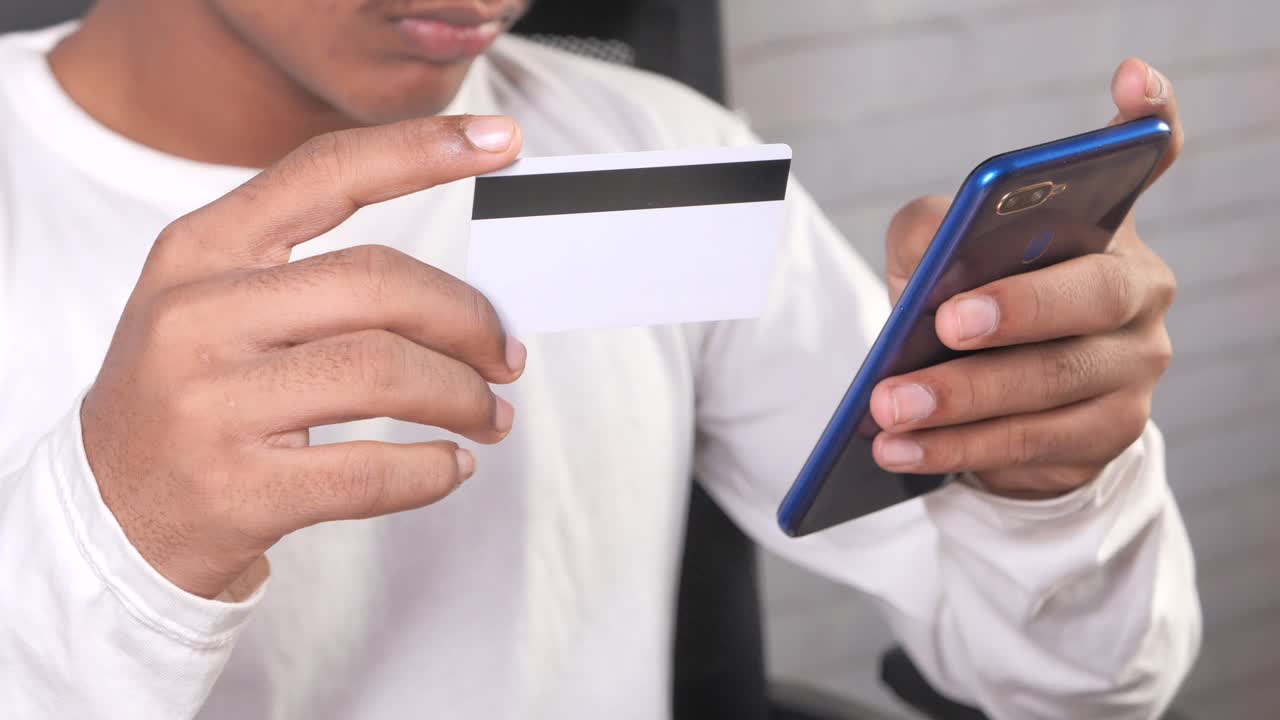 persona que utiliza un teléfono móvil para el pago con tarjeta de crédito