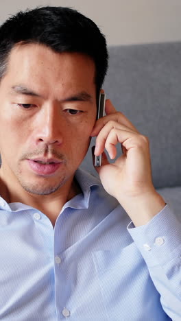 거실 에서 휴대 전화 로 이야기 하는 사람