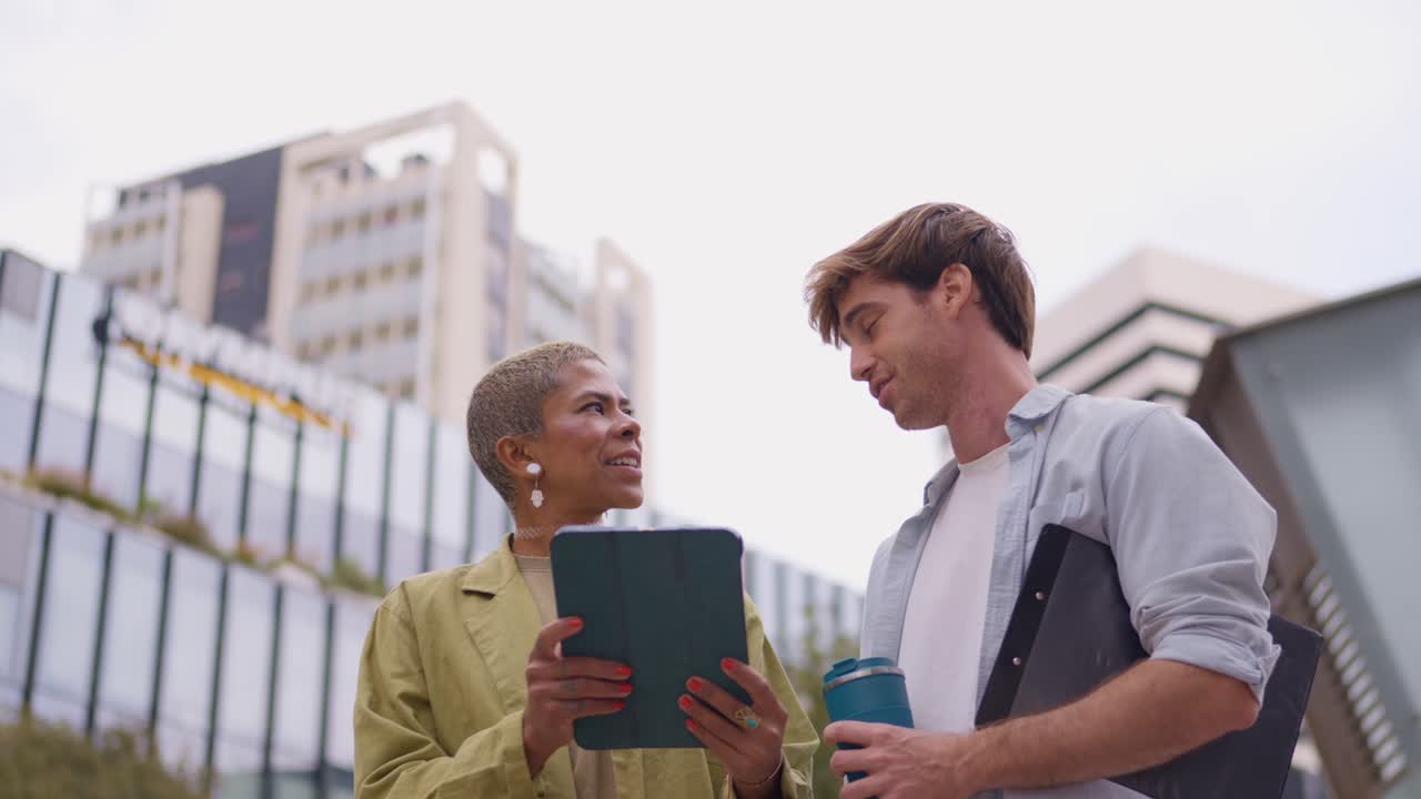 Business colleagues having a meeting with a tablet outdoors