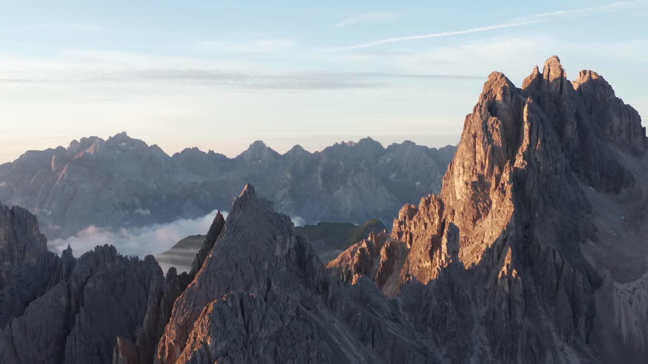 Ripresa aerea in tracking di una splendida catena montuosa con vetta rocciosa all'alba in Italia – Cadini di Misurina, Dolomiti