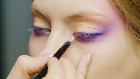 apply makeup on a beautiful female eye of blue color