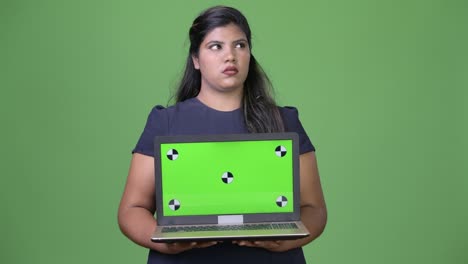 joven sobrepeso hermosa mujer de negocios india contra fondo verde