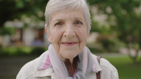 portrait of senior elderly caucasian woman smiling happy enjoying day in park