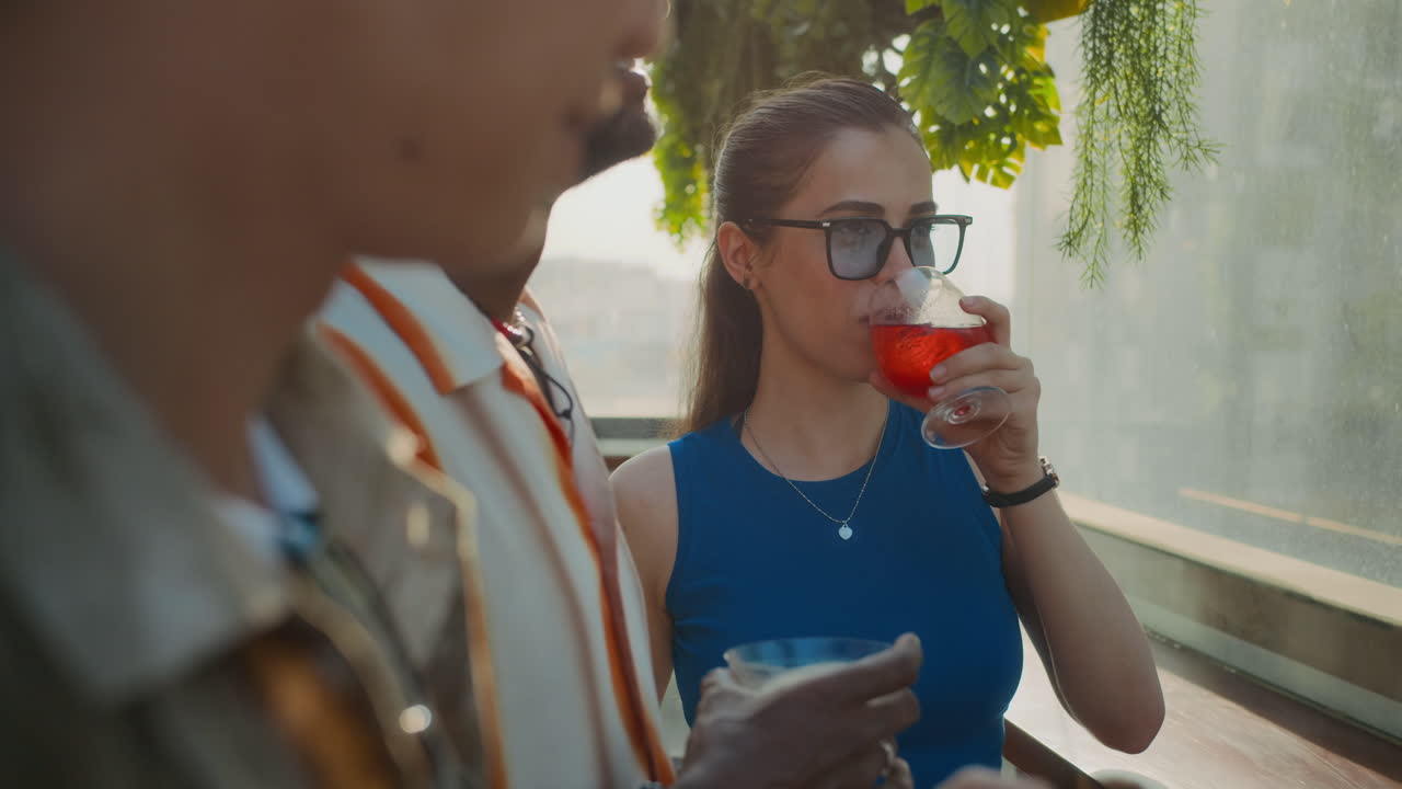 Friends Enjoying City View when Visiting Bar and Drinking Cocktails at Sunset