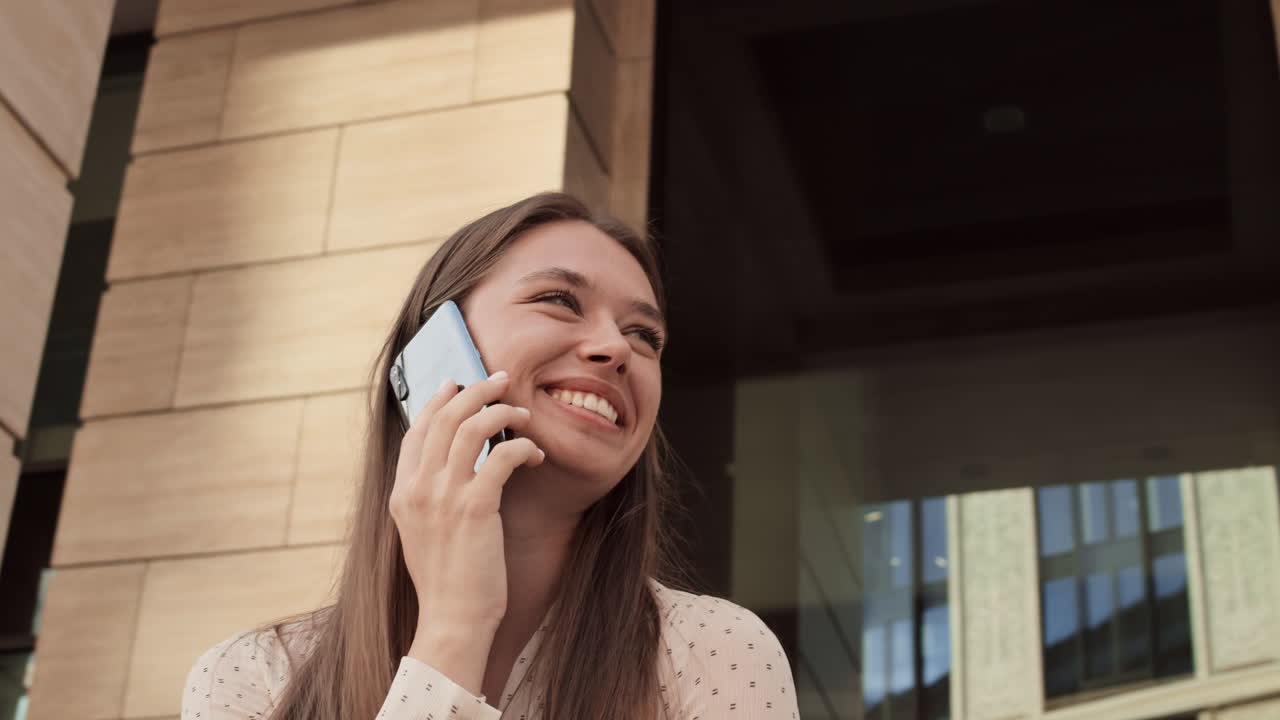 Woman Talking on Phone by Building