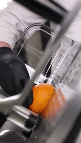 chef using a citrus slicer to prepare an orange