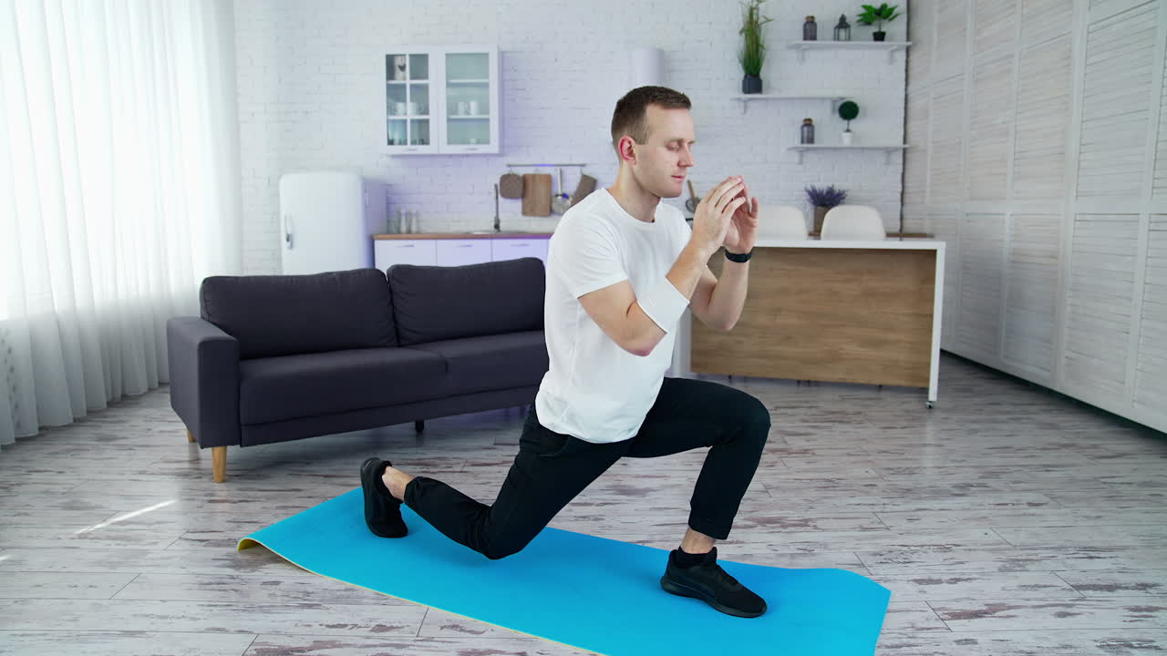 Healthy athletic man training in home.Fit man in t-shirt doing exervises.