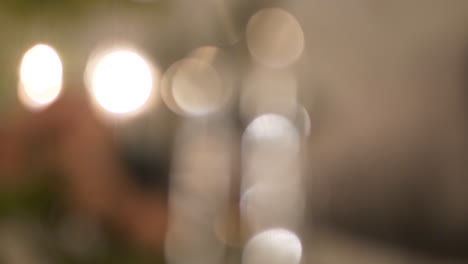 blurry background shot of person decorating christmas tree