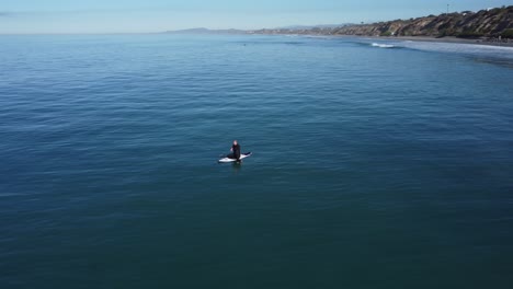 Eine-Schöne-Luftdrohnenaufnahme,-Drohne,-Die-Einen-Mann-Verfolgt,-Der-Im-Ozean-In-Der-Nähe-Des-Strandes,-Carlsbad-State-Beach---Kalifornien,-Speit