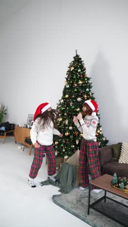 hermanas bailando alrededor del árbol de navidad