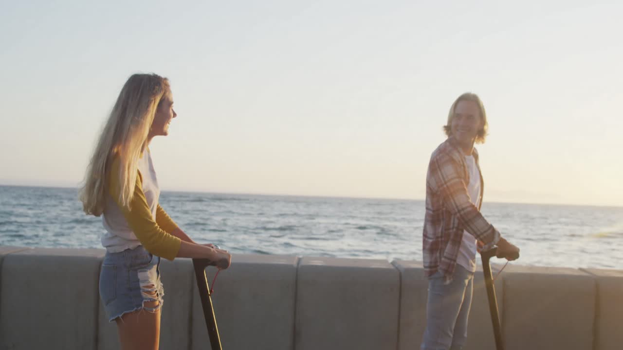 백인 부부가 바 ⁇ 가에서 시간을 즐기고 있습니다.