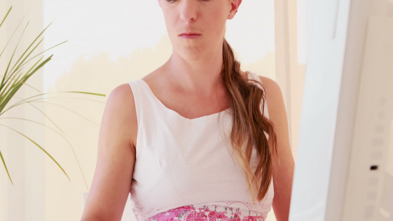 전화 를 하는 동안 컴퓨터 를 사용 하는 미소 짓는 여자