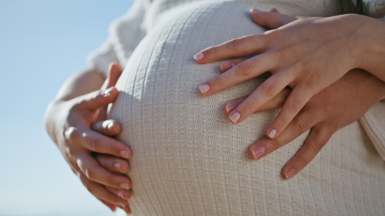 Expectant parents hands touching big female belly close up. Pregnant couple