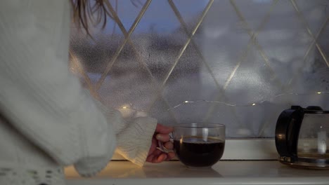 woman with mug of fresh brewed coffee in window medium shot