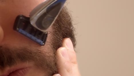 a detailed close-up of a bearded man shaving a part of his face, focusing on grooming and precision.