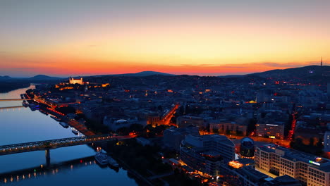 stunning view of old city in bratislava, slovakia. streets are well-illuminated at the time of dusk. aerial perspective