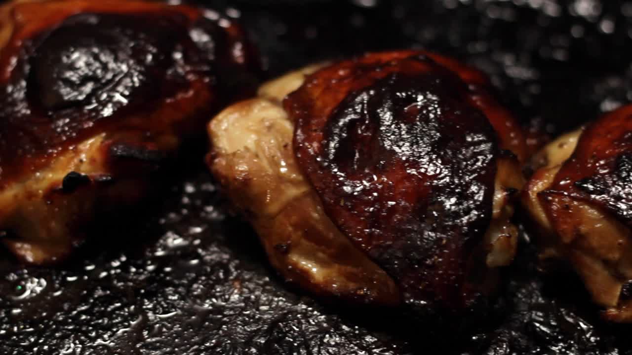 Burned over chicken meat on stove reveal, closeup
