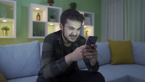 Joven-Feliz-Usando-El-Teléfono-En-Casa,-Agradable-Y-Divertido.