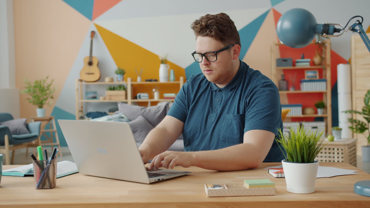hombre trabajando en una computadora portátil en casa