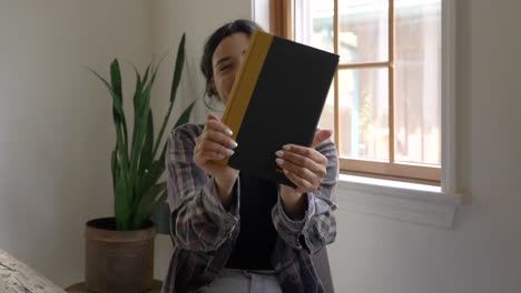 joyful puerto rican girl looking at camera happy smiling gratitude with new reading book