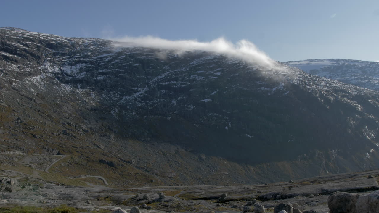 노르웨이의 화창한 날 산꼭대기 위로 구르는 구름의 저속