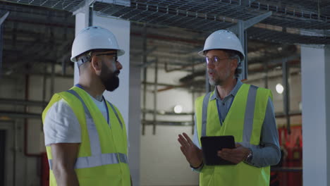 construction workers discussing project in electrical room