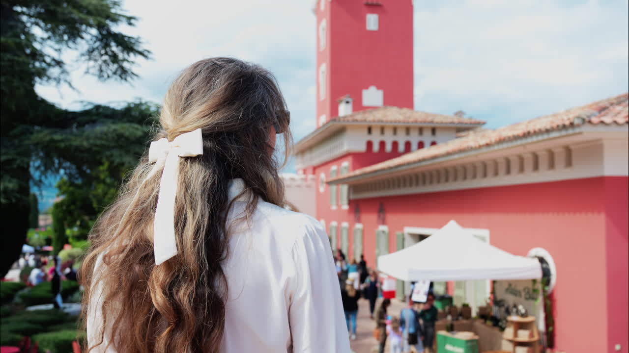 Woman with long hair, dressed in white, posing at the Cremat Castle Winery