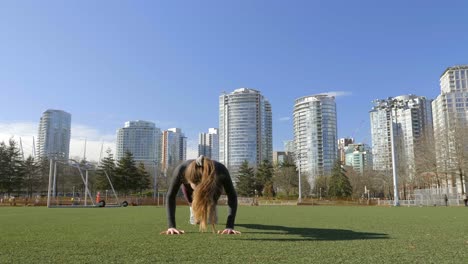 fit young woman doing burpees bodyweight exercise in park