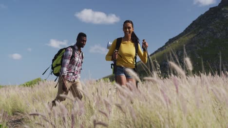 pareja afroamericana caminando mientras trekking en las montañas