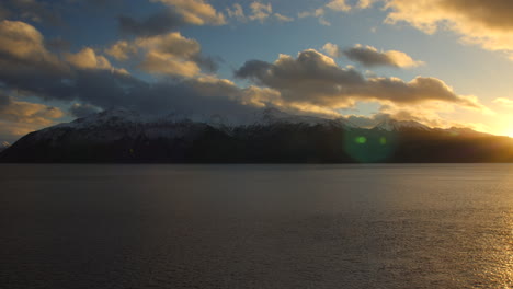 nubes en movimiento lento al atardecer sobre las montañas de la península de kenai vistas a través del brazo turnagain cerca de anchorage, alaska