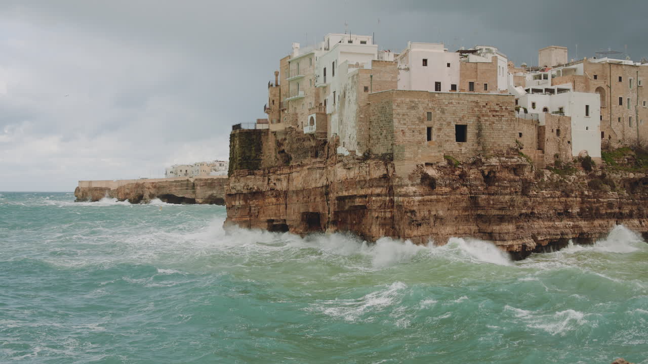 Onde che si infrangono sulle scogliere di Polignano a Mare durante una tempesta nel Mare Adriatico, Bari, Italia. Slowmotion 4K 120fps