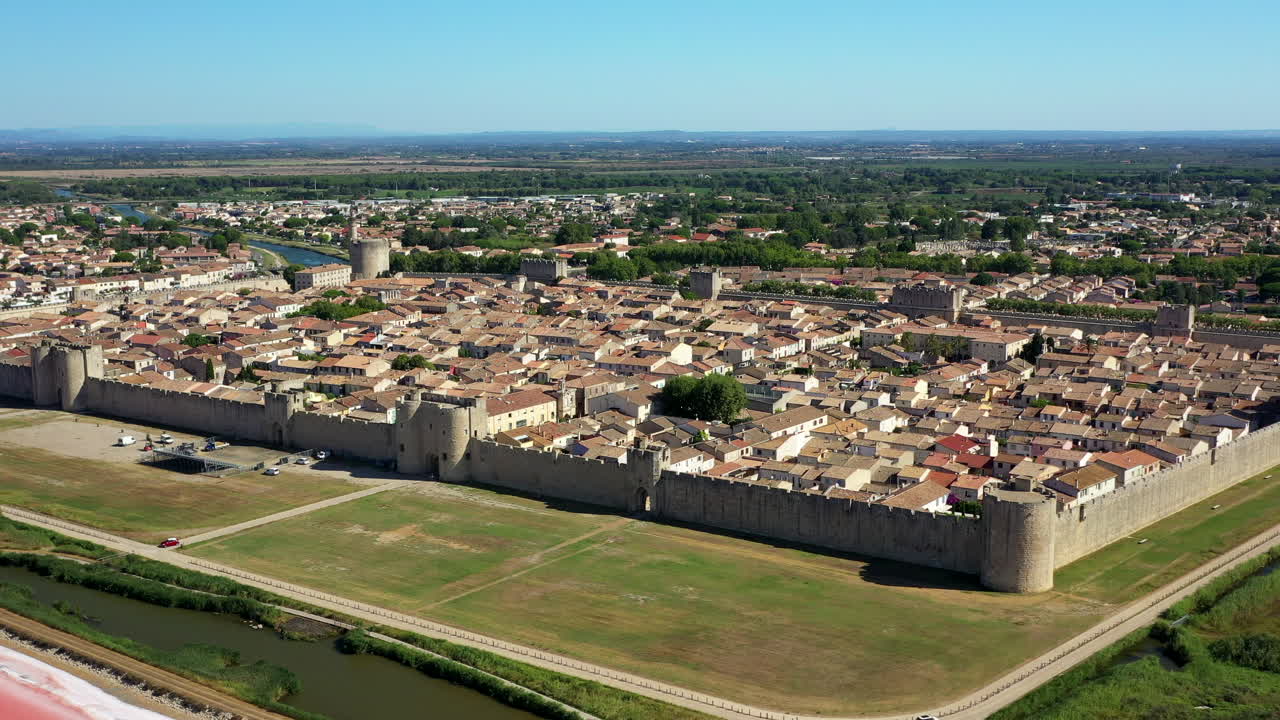 la ciudad histórica de aigues-mortes en la camarga, francia durante un día soleado de verano que se encuentra junto a un lago de sal rosa