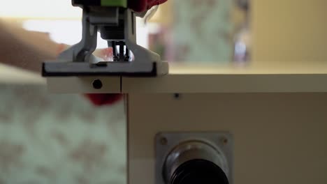 master of furniture production saws the surface of the table with an electric jigsaw 1