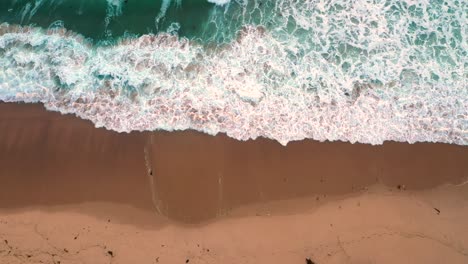 Vista-Aérea-De-Las-Olas-Del-Mar-Rodando-En-La-Playa-Vacía