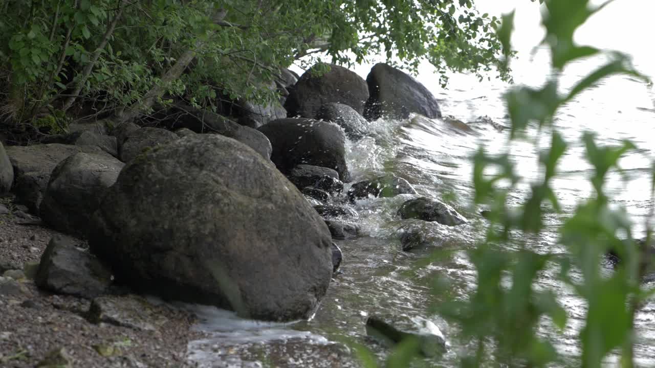 olas a cámara lenta en la costa con rocas