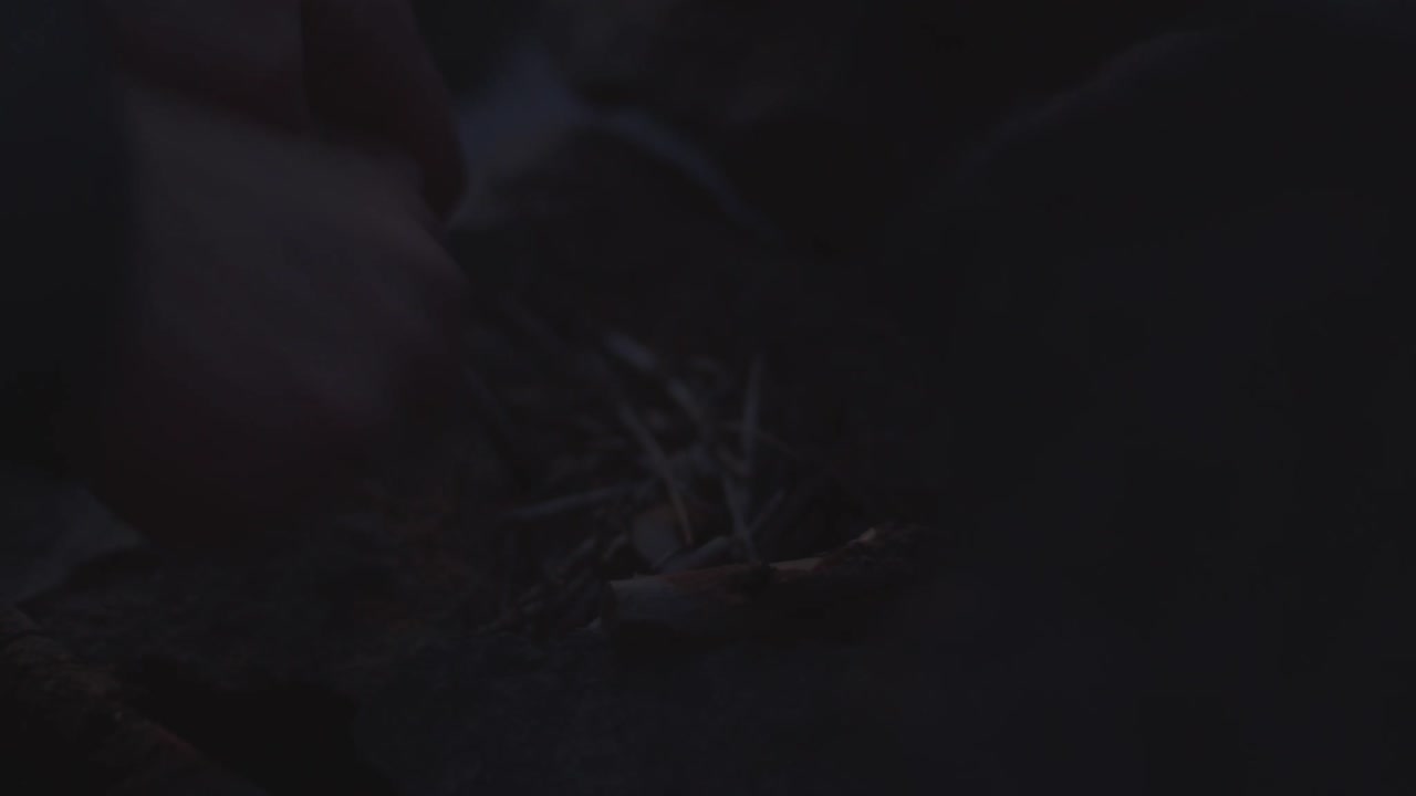 persona irreconocible frotando palos de madera para encender fuego