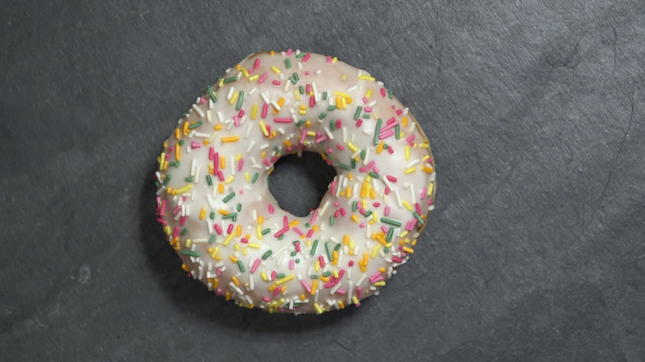 сладкий пончик вращается на темном фоне. традиционная американская сладость