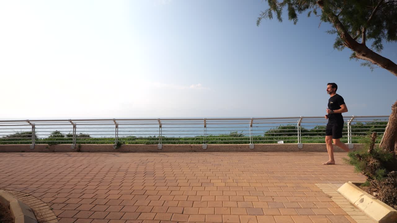 40대 남자가 운동복을 입고 조 ⁇ 을 하고 있으며 느린 영상으로 촬영되었습니다.